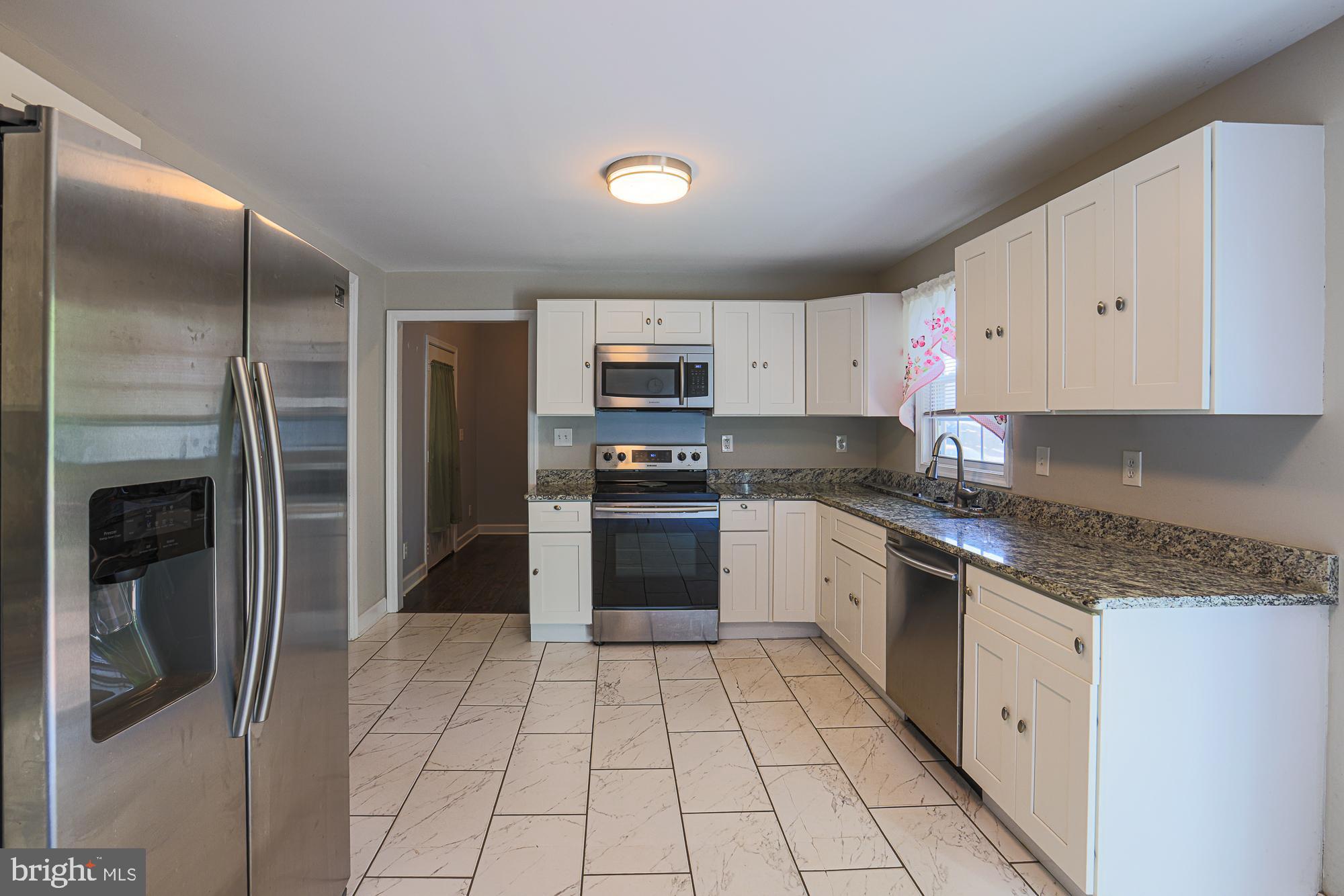 7933 34th Street Rosedale, MD 21237 - Photo 12 of 32 a kitchen with stainless steel appliances granite countertop a refrigerator and a stove