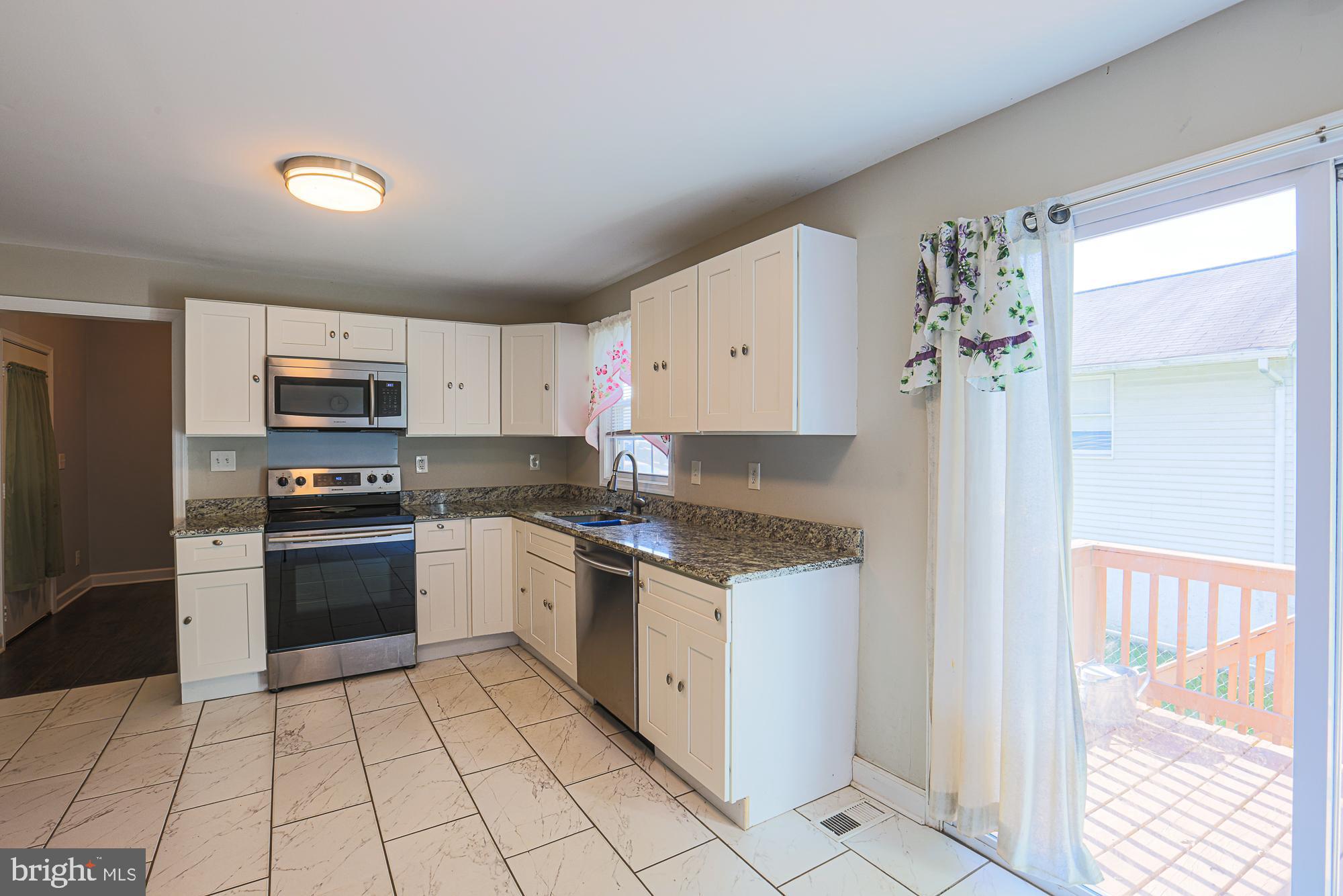 7933 34th Street Rosedale, MD 21237 - Photo 14 of 32 a kitchen with stainless steel appliances granite countertop a stove a sink and a refrigerator