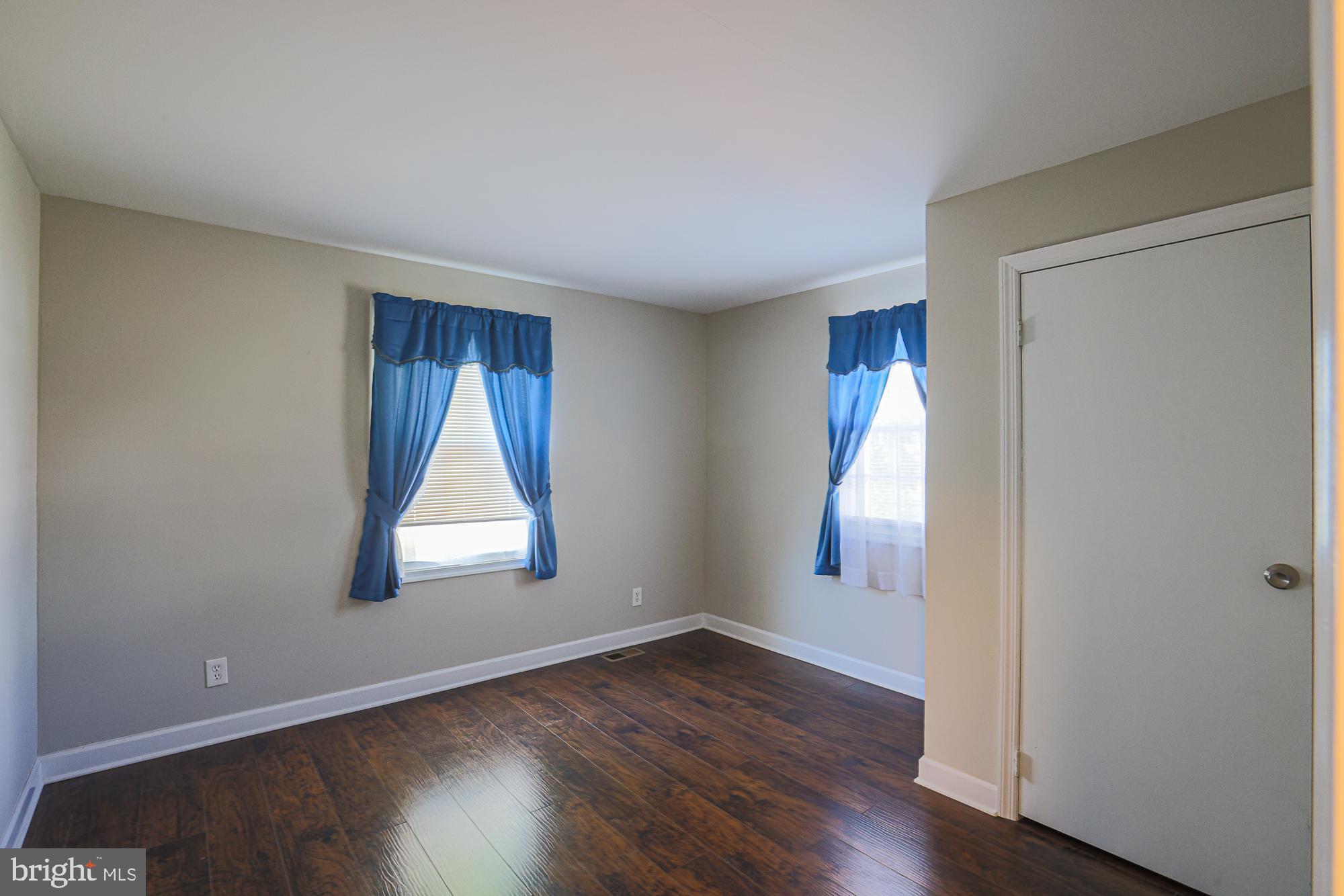 7933 34th Street Rosedale, MD 21237 - Photo 17 of 32 an empty room with wooden floor and windows