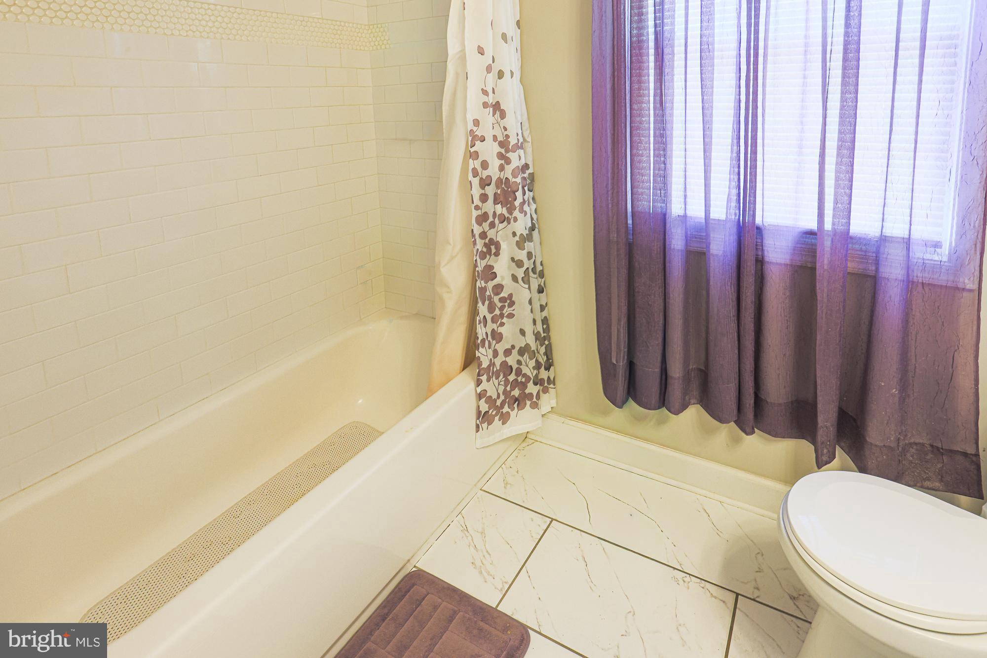 7933 34th Street Rosedale, MD 21237 - Photo 19 of 32 a bathroom with a bathtub and shower