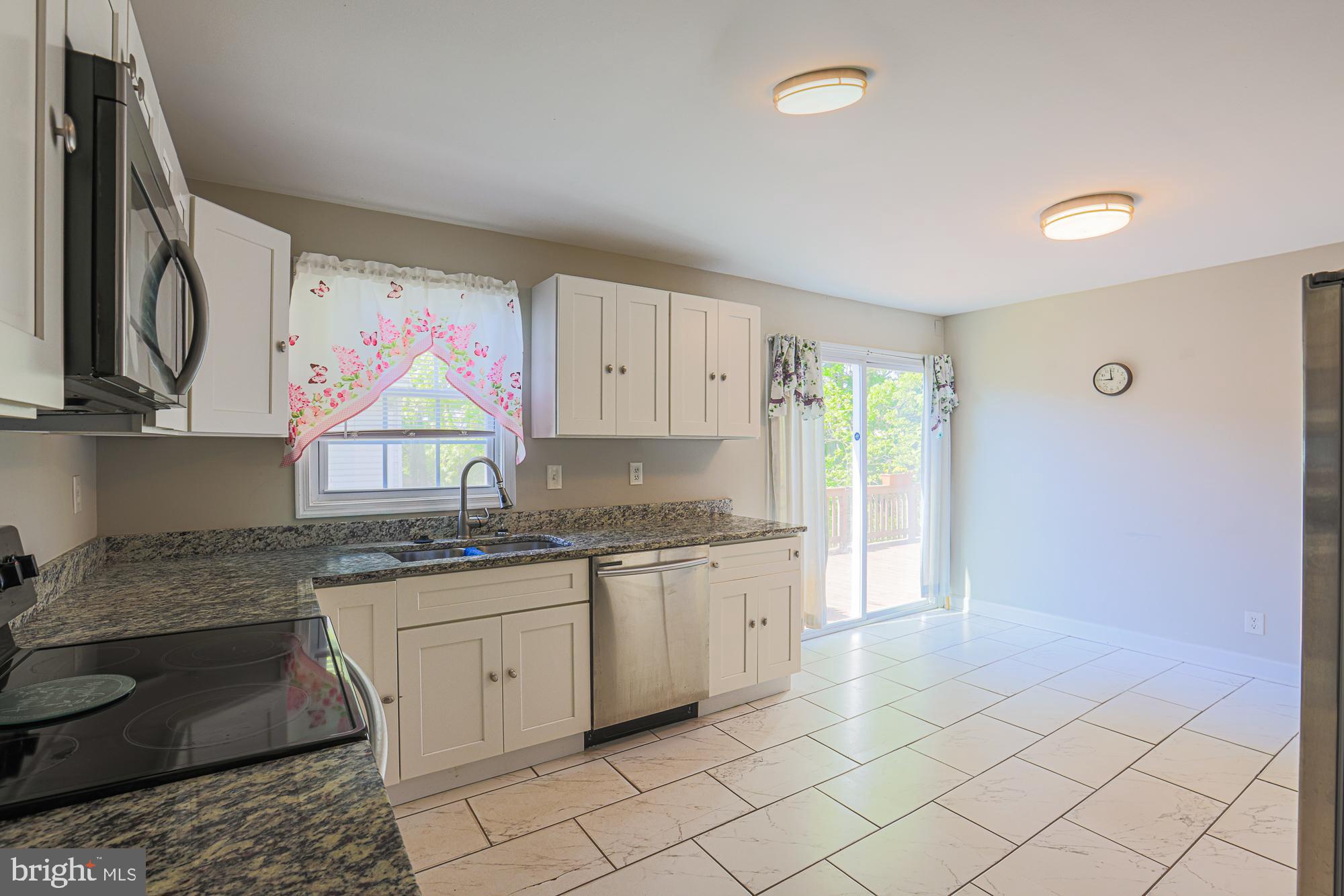 7933 34th Street Rosedale, MD 21237 - Photo 10 of 32 a kitchen with granite countertop a sink cabinets and stainless steel appliances