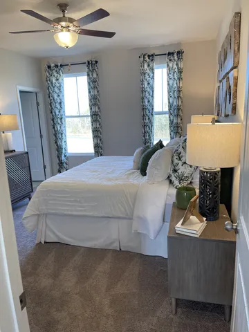 a bedroom with a bed table and window