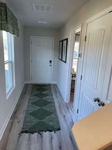 a view of a hallway with wooden floor and staircase