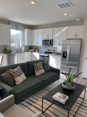 a living room with furniture kitchen and a table