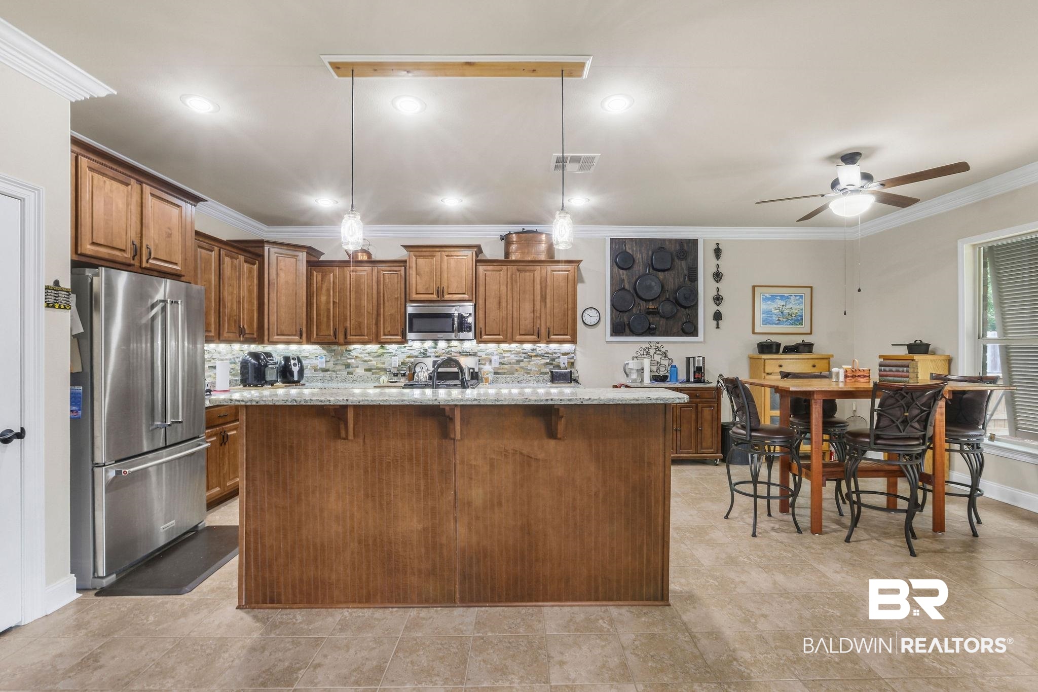 1086 Destin Avenue Foley, AL 36535 - Photo 3 of 30 Kitchen featuring a kitchen island with sink, stainless steel appliances, ornamental molding, light stone countertops, and decorative light fixtures