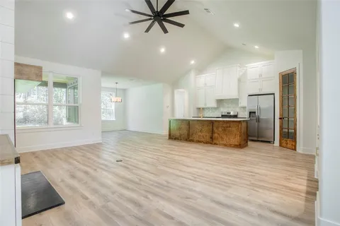 a view of an empty room with window and wooden floor