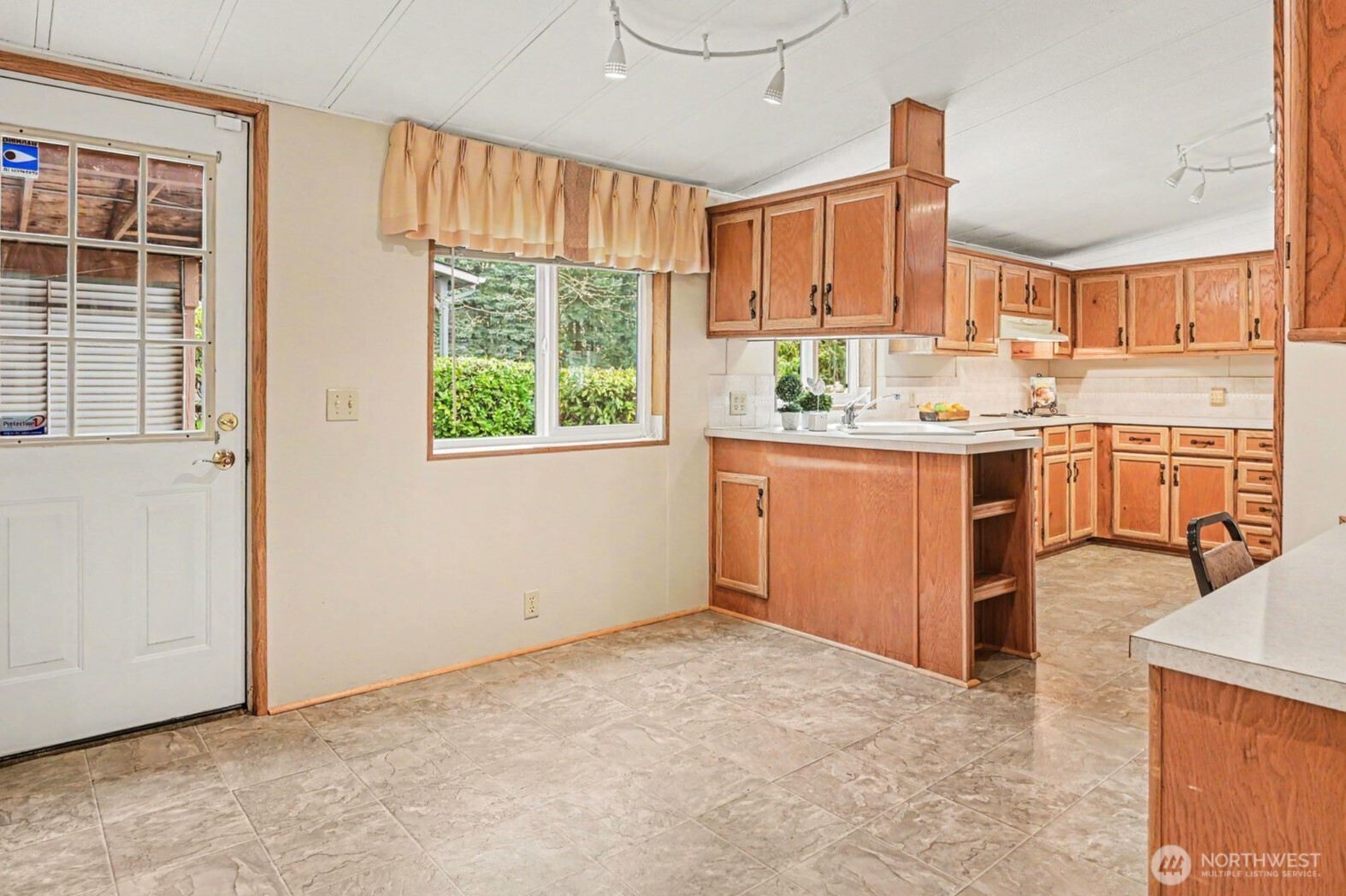 17308 Woodcrest Drive Northeast Bothell, WA 98011 - Photo 16 of 38 a kitchen with kitchen island granite countertop wooden cabinets a stove a sink and a window