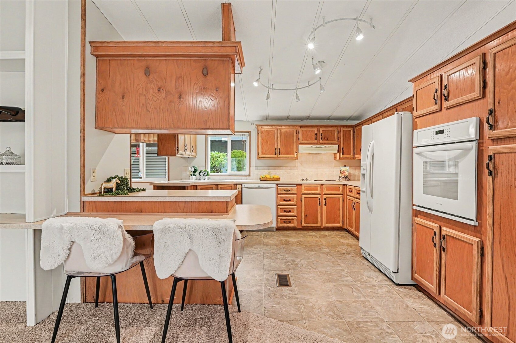 17308 Woodcrest Drive Northeast Bothell, WA 98011 - Photo 17 of 38 a kitchen with stainless steel appliances granite countertop a refrigerator a sink a stove and white cabinets with wooden floor