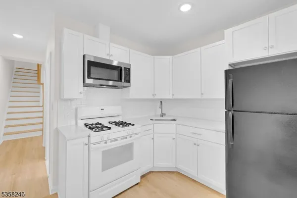 a kitchen with white cabinets and white appliances