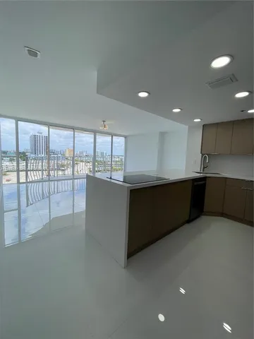 a large room with stainless steel appliances wooden cabinets and a large window