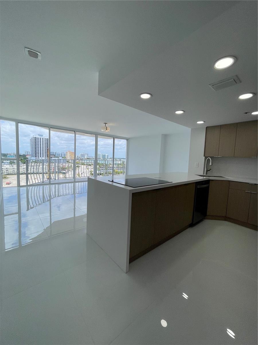 a large room with stainless steel appliances wooden cabinets and a large window