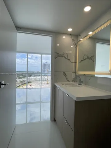 a bathroom with a sink a large mirror and a shower