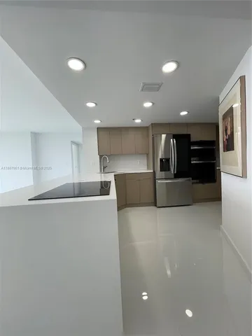 a view of kitchen with kitchen island and stainless steel appliances