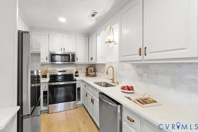 a kitchen with stainless steel appliances granite countertop a refrigerator and a stove