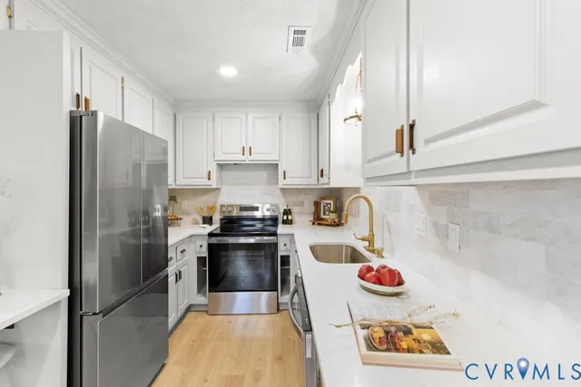 a kitchen with stainless steel appliances a refrigerator sink and cabinets