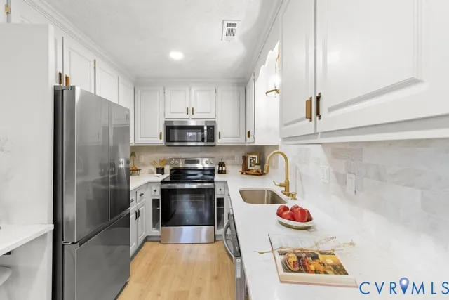 a kitchen with stainless steel appliances a refrigerator sink and microwave