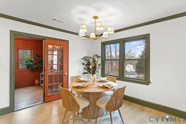 a open dining room with furniture a chandelier and kitchen view