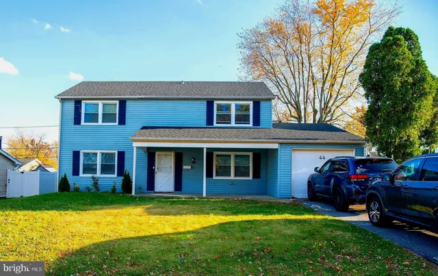 a front view of a house with yard and green space