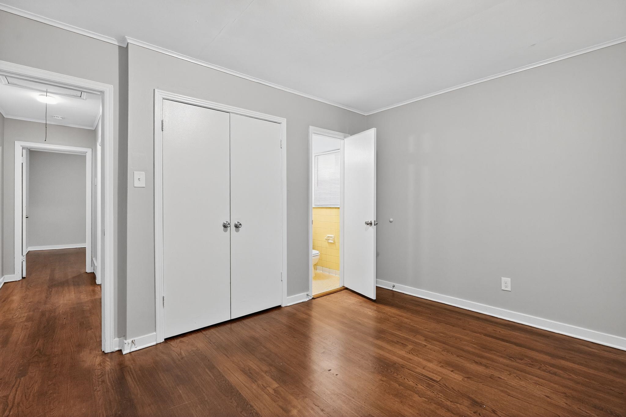 177 East Raines Road Memphis, TN 38109 - Photo 22 of 32 Unfurnished bedroom featuring attic access, ornamental molding, dark wood finished floors, and a closet