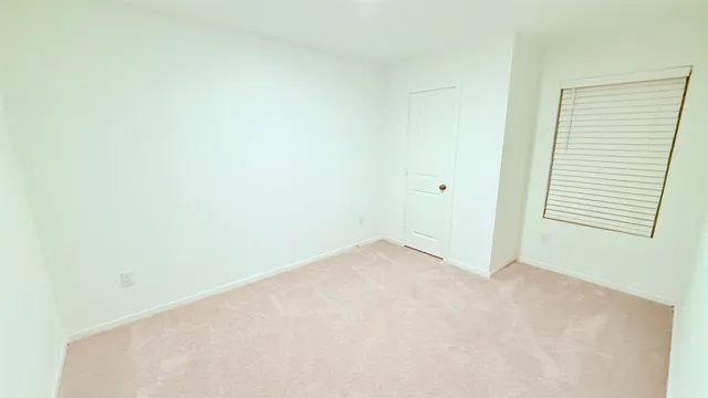 a view of a big room with wooden floor and a window