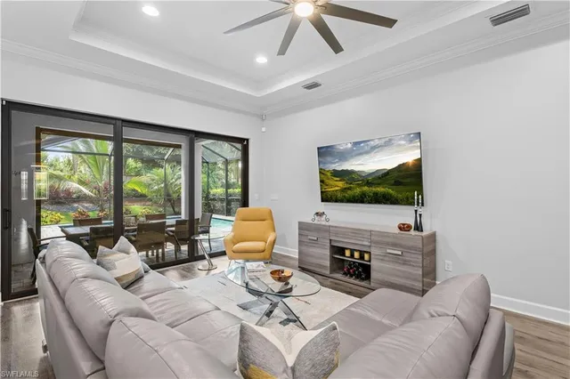 a living room with furniture a flat screen tv and a large window