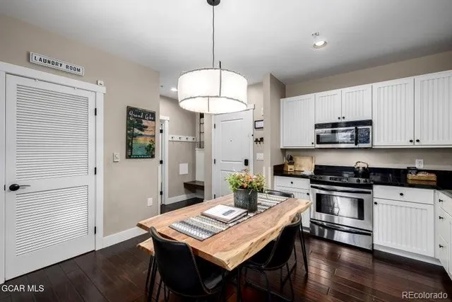 a kitchen with kitchen island a stove a table and chairs in it
