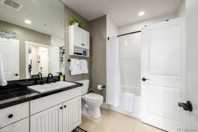 a bathroom with a double vanity sink toilet and shower