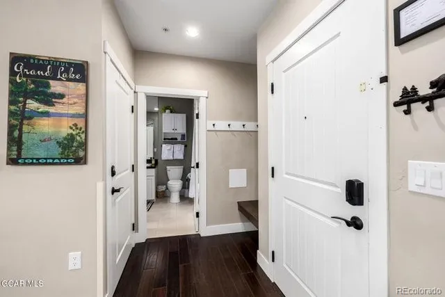 a view of a hallway with wooden floor and closet