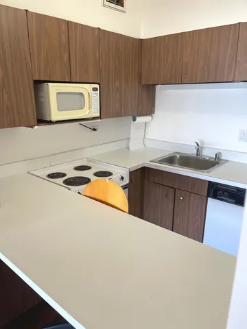 a kitchen with a sink a microwave and cabinets