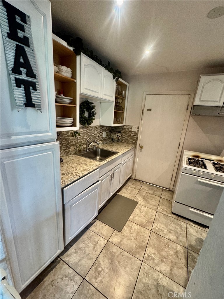 1203 West 134th Place Compton, CA 90222 - Photo 21 of 23 a kitchen with a stove and a refrigerator