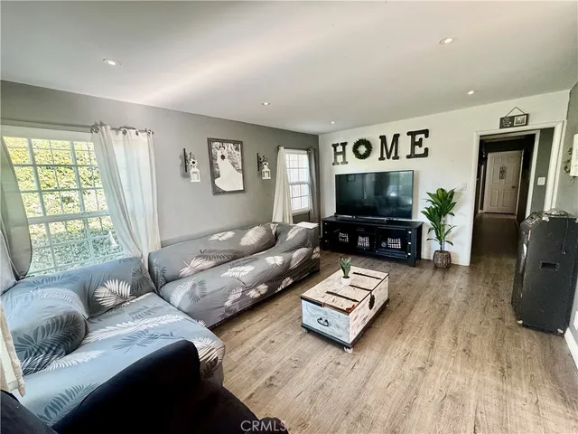 a living room with furniture window and wooden floor