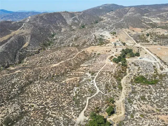 a view of a dry field with mountains in the background