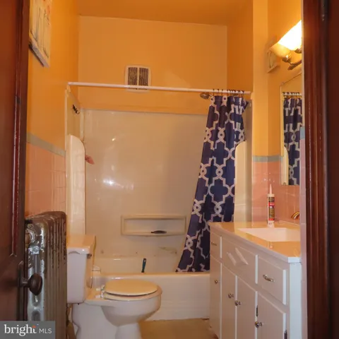 a bathroom with a toilet and a shower curtain
