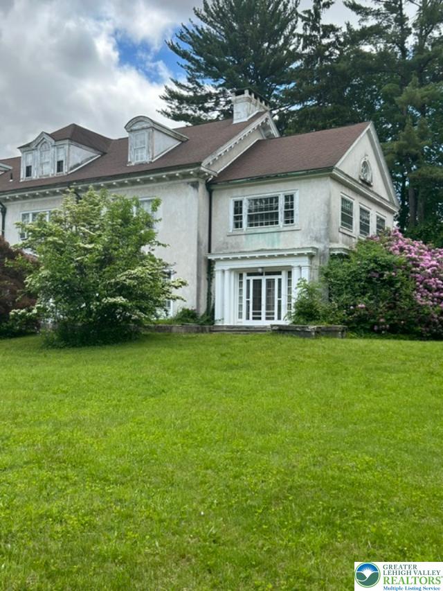 1170 Mosser Road Breinigsville, PA 18031 - Photo 3 of 19 A stately manor awaits with dormer windows and classic architectural details, nestled amidst lush landscaping.