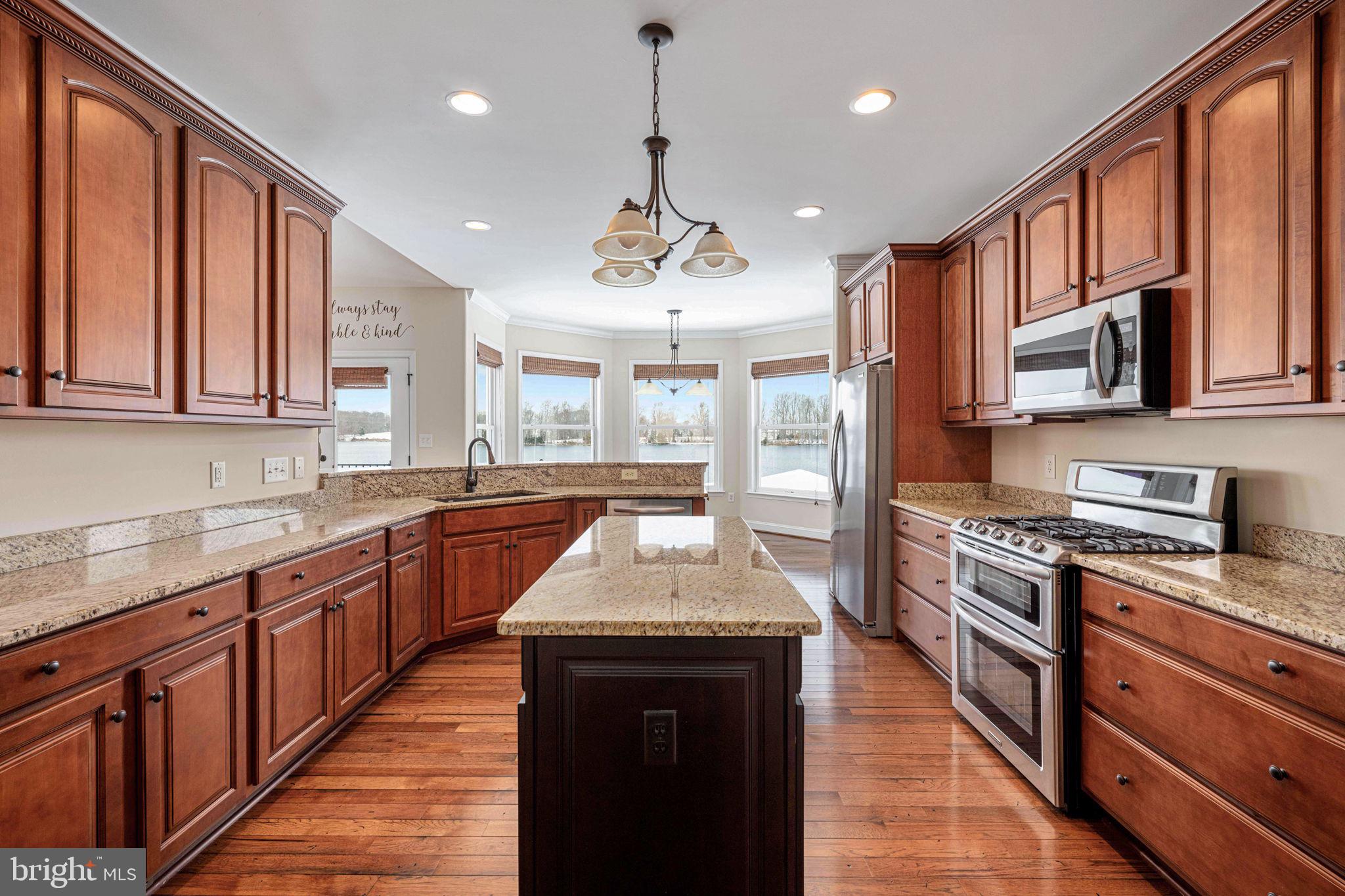 263 Lane Road Bumpass, VA 23024 - Photo 63 of 84 a large kitchen with stainless steel appliances granite countertop a stove top oven a sink dishwasher a dining table and chairs with wooden floor