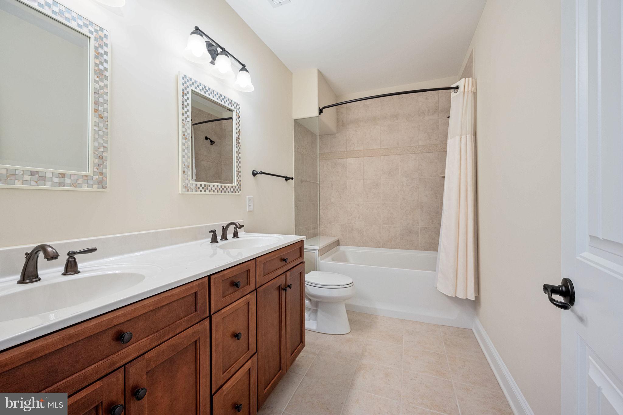 263 Lane Road Bumpass, VA 23024 - Photo 81 of 84 a bathroom with a double vanity sink toilet mirror and shower