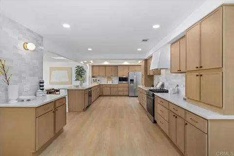 a large kitchen with stainless steel appliances lots of counter top space