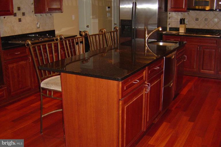 622 Church Road Reisterstown, MD 21136 - Photo 20 of 21 a kitchen with stainless steel appliances granite countertop a sink a stove and a wooden floors