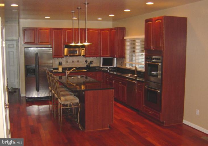 622 Church Road Reisterstown, MD 21136 - Photo 10 of 21 a kitchen with stainless steel appliances granite countertop a refrigerator a stove a sink a dining table and chairs