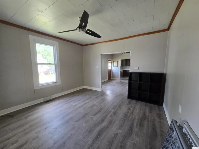 a living room with hard wood floors and a ceiling fan