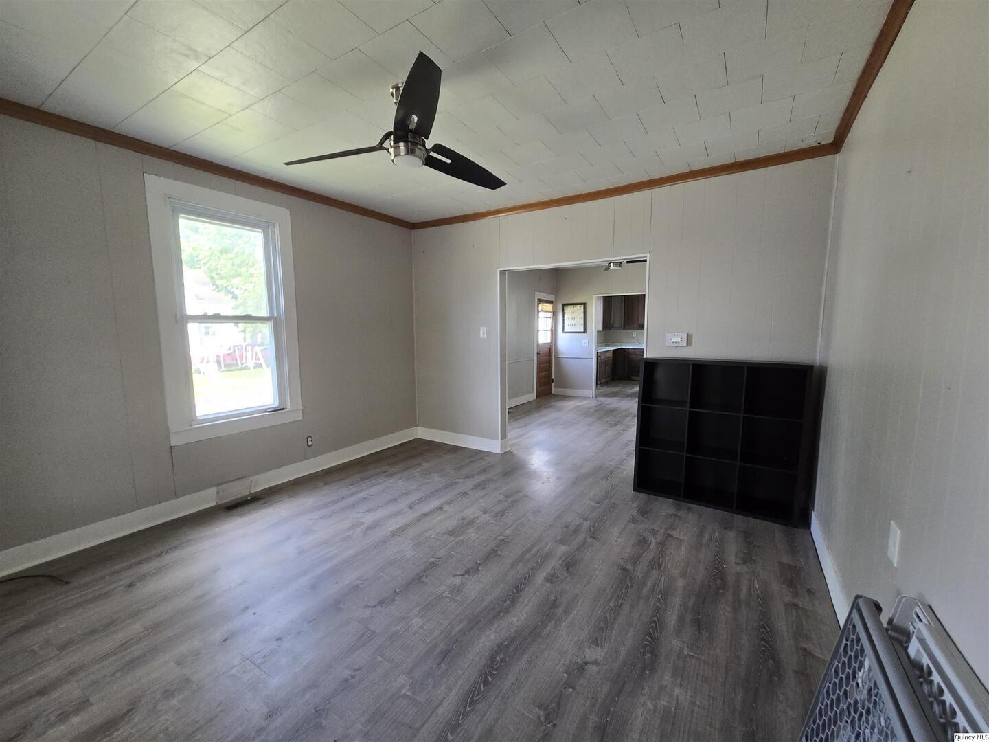 112 North Walnut Street Versailles, IL 62378 - Photo 2 of 18 a living room with hard wood floors and a ceiling fan