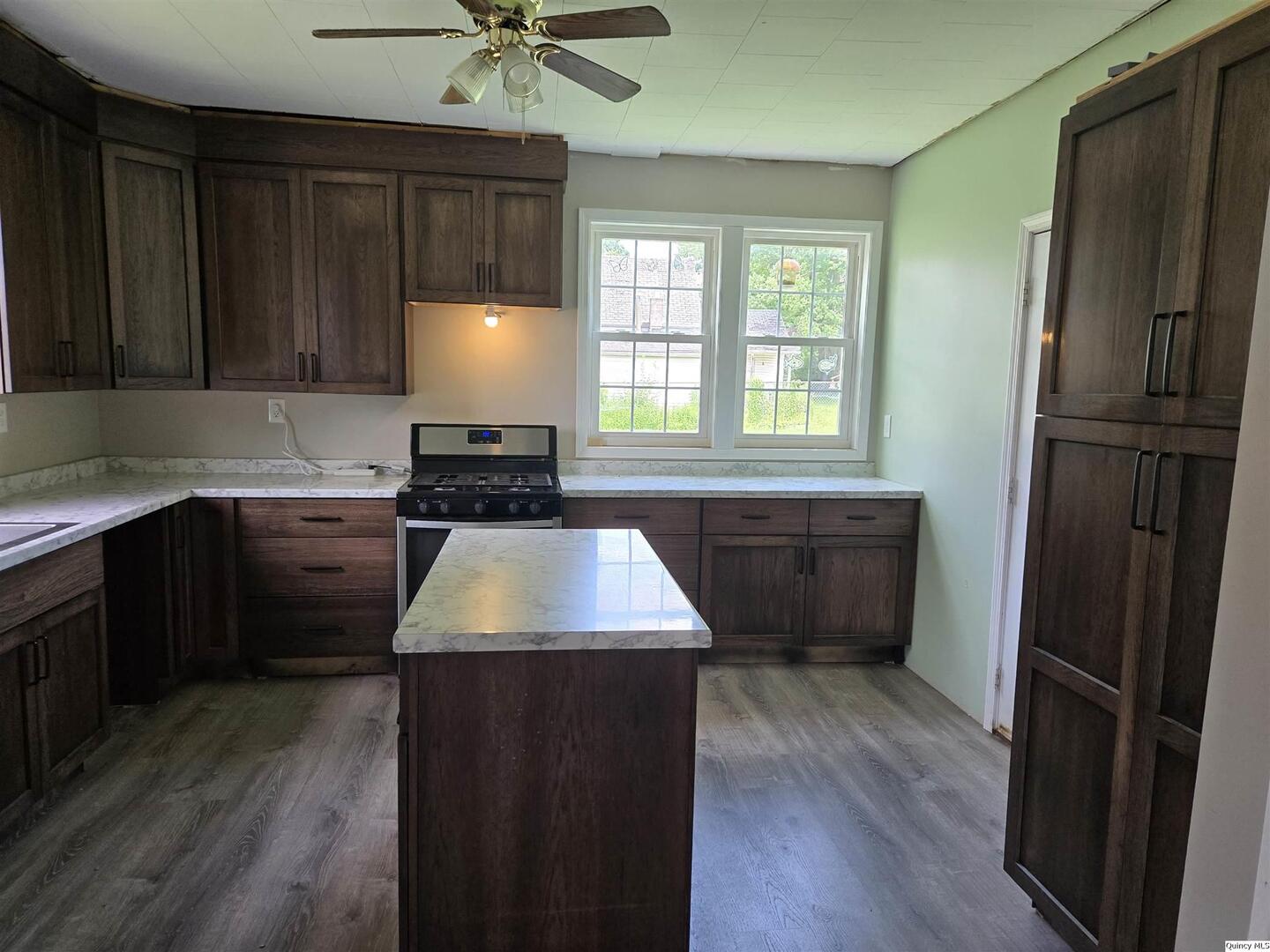 112 North Walnut Street Versailles, IL 62378 - Photo 7 of 18 a kitchen with granite countertop a refrigerator a sink dishwasher stove and oven with wooden floor