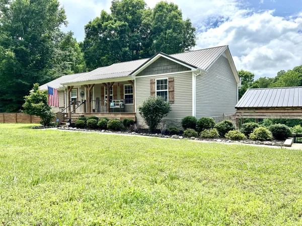 a front view of a house with yard and green space