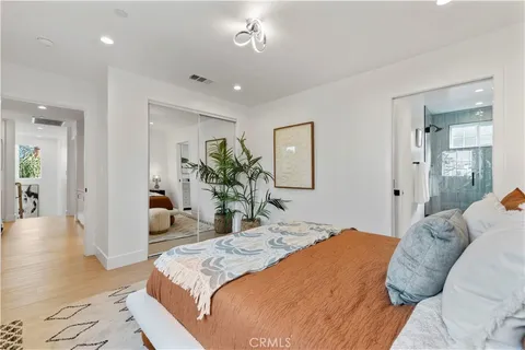 a bedroom with a large bed and a potted plant