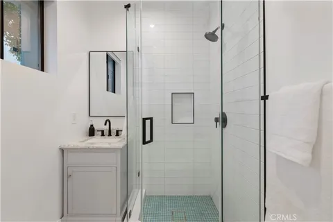 a bathroom with a sink vanity and shower