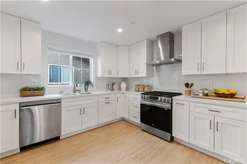 a kitchen with granite countertop white cabinets and stainless steel appliances