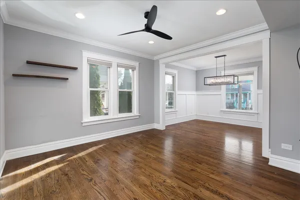 a view of an empty room with window and wooden floor