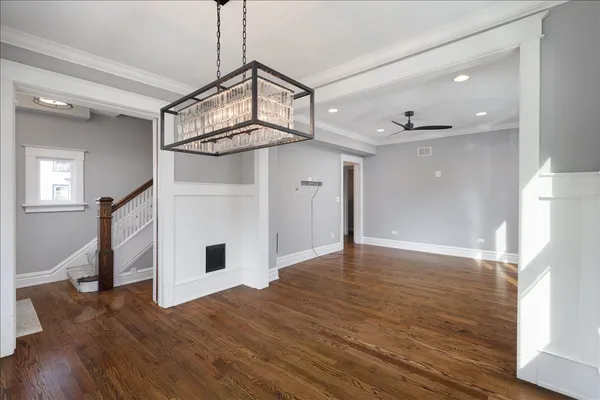 a view of a livingroom with wooden floor and a ceiling fan