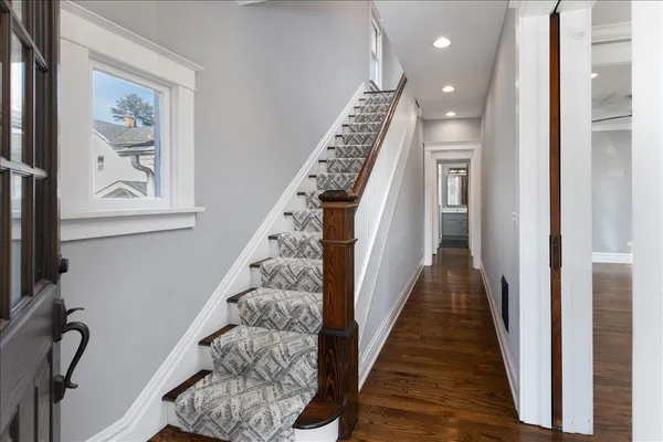a view of a hallway with wooden floor and stairs