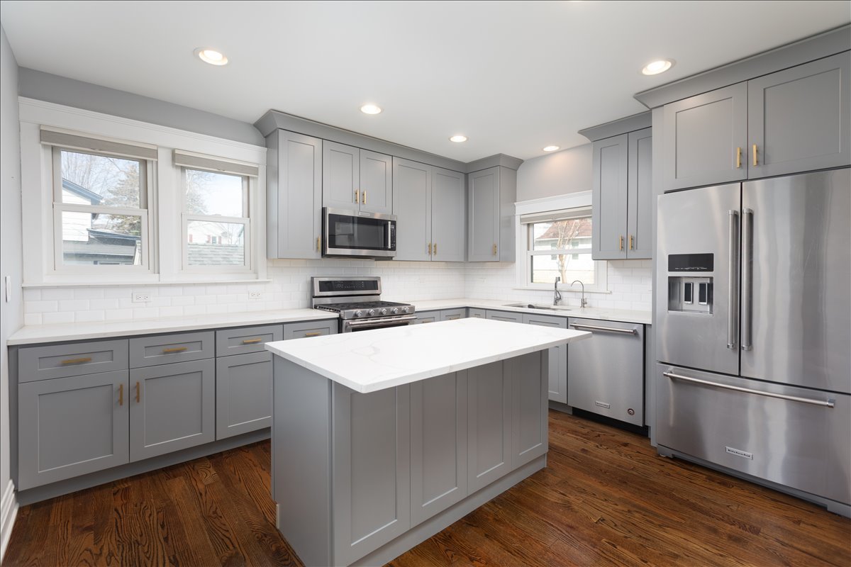 18 North Main Street Naperville, IL 60540 - Photo 6 of 32 a kitchen with a sink a microwave a refrigerator and cabinets